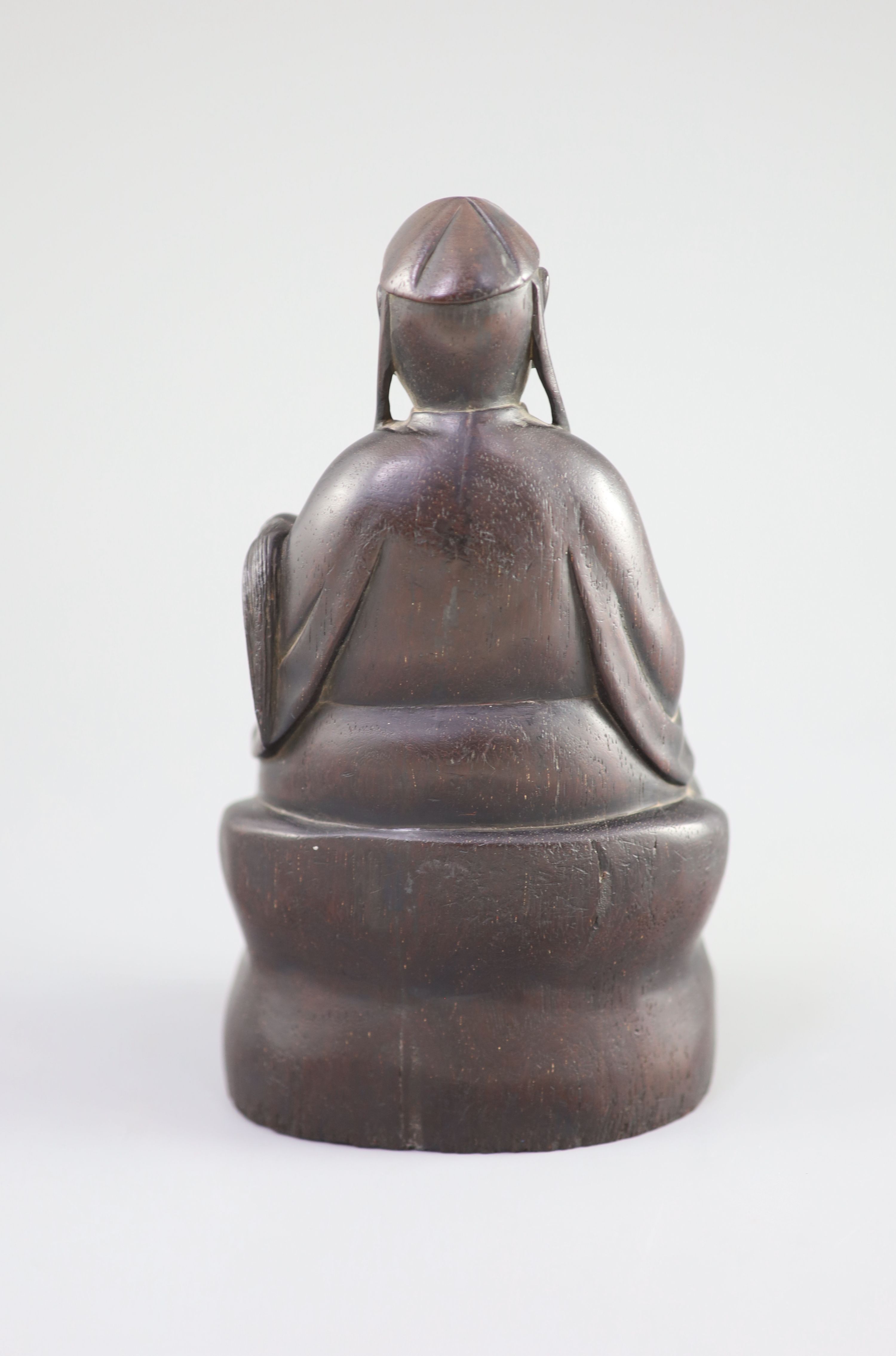 A Chinese Zitan seated figure of an official, 18th century, 19.3cm high